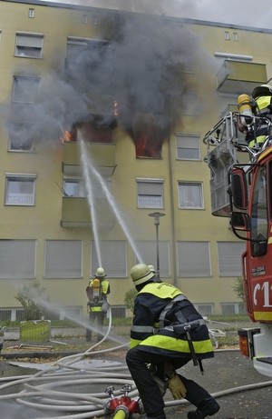 Feuerwehrmänner löschen Brand, © Ein 34-Jähriger setzte vermutlich seine Wohnung aus Verzweiflung in Brand Foto: Feuerwehr München