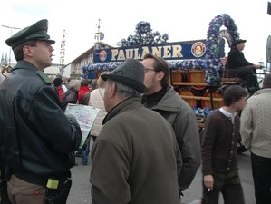 Ein Polizist unterhält sich auf dem Oktoberfest mit zwei Besuchern, © Polizei München