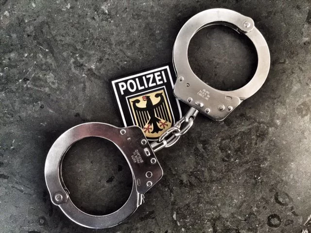 Handschellen vor einem Bundespolizei-Wappen — © Symbolfoto