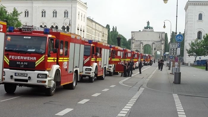 Feuerwehrfahrzeuge in einer Reihe hintereinander vor dem Siegestor in München — © Feuerwehr bedankt sich bei Münchner Bevölkerung