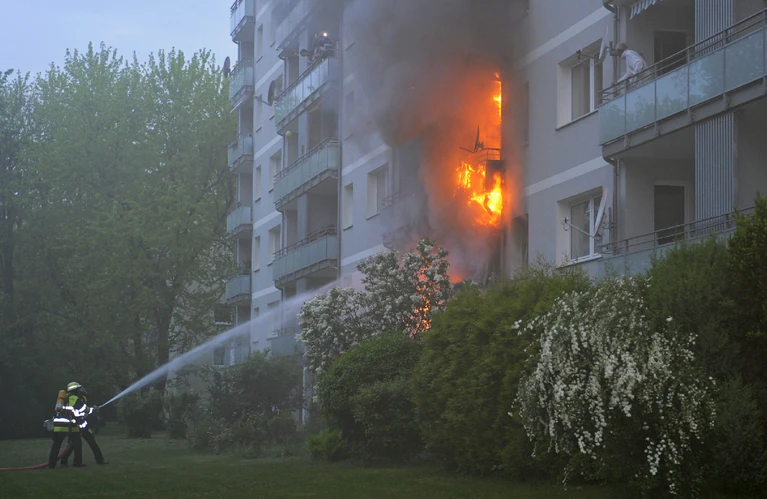 Flammen schießen aus dem Wohnhaus, die Feuerwehr löscht — © Flammen schießen aus dem Wohnhaus als die Feuerwehr eintrifft Foto: Berufsfeuerwehr München