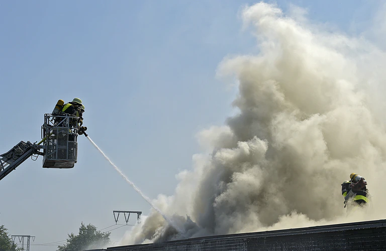 Feuerwehrmann löscht Brand auf Dach — © Foto: Berufsfeuerwehr München