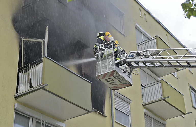 Feuerwehrmänner löschen einen Brand von der Hebebühne aus — © Ein 34-Jähriger setzte vermutlich seine Wohnung aus Verzweiflung in Brand Foto: Feuerwehr München