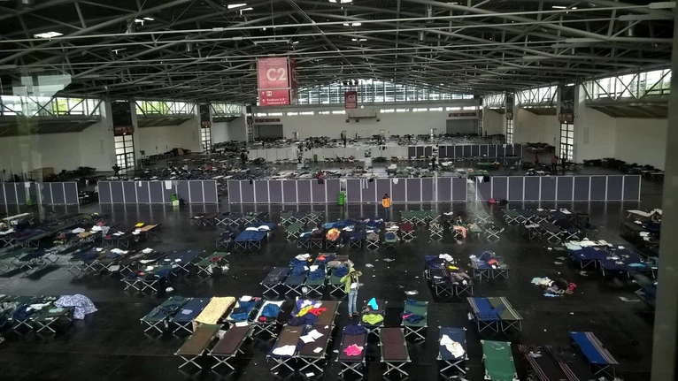 Die Flüchtlinge liegen eng zusammengepfercht in der Messehalle