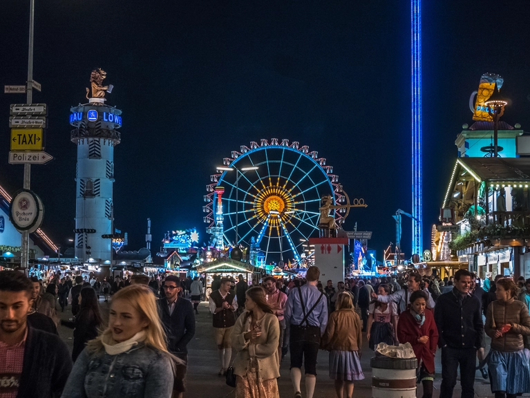 Riesenrad und Skyfall-Tower glänzen bei Nacht — © Der Ausblick aufs Münchner Oktoberfest - Die Wirtsbudenstraße auf der Wiesn