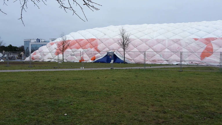 — © Die Traglufthalle in Neubiberg ist in sich zusammengesackt - Mehr als 200 Menschen mussten in Turnhallen gebracht werden.