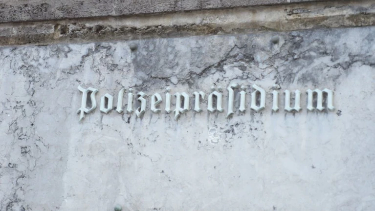 schriftzug an der außenmauer des polizeipräsidium muenchens