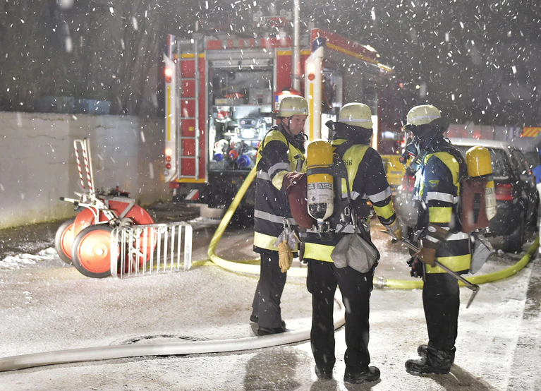 feuerwehr einsatzkräfte im schnee mit löschrohr — © Berufsfeuerwehr München