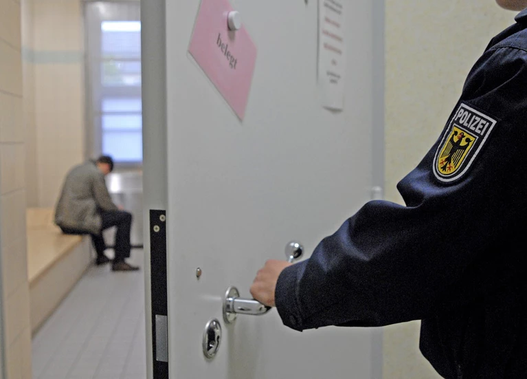 Bundespolizeibeamter schließt Zellentür — © Symbolbild - Foto: Bundespolizei