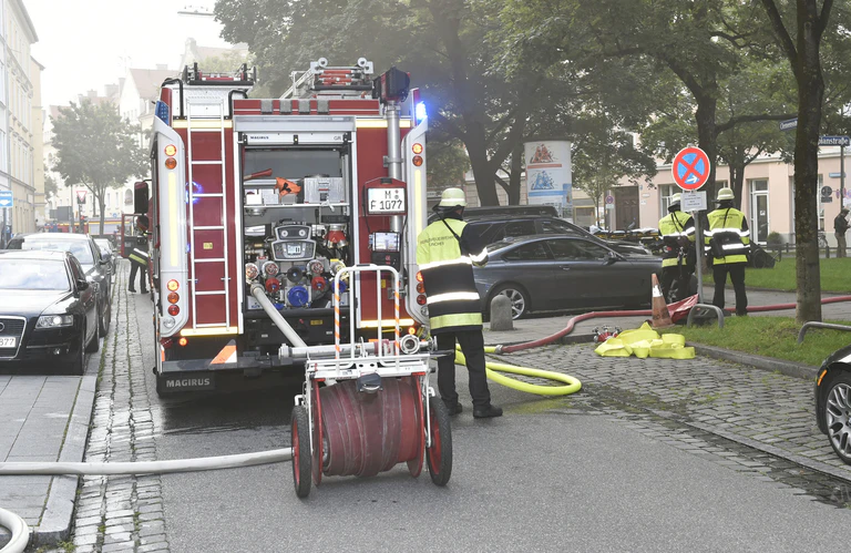 Feuerwehrmänner mit einem Feuerwehrauto in der Clemesstraße löschen mit Wasserschlauch — © Feuerwehreinsatz Clemensstraße