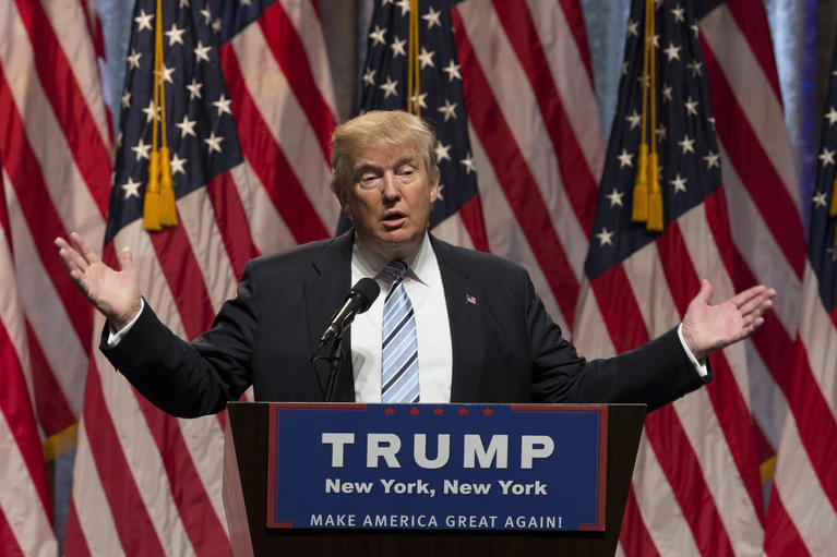 US-Präsident Donald Trump am Rednerpult mit US-Flaggen im Hintergrund