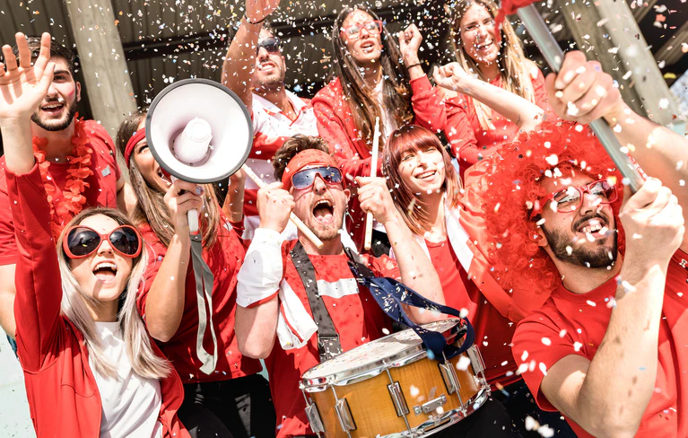 — © Foto fotolia.com, : <a href="https://stock.adobe.com/de/images/young-football-supporter-fans-cheering-with-flag-and-confetti-watching-soccer-match-at-stadium-friends-people-group-with-red-t-shirts-having-excited-fun-on-sport-world-championship-concept/201394482" target="_blank"> © Mirko </a>
