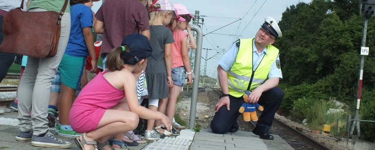 Ein Bundespolizist erklärt Kindern, wie man sich an Bahngleisen richtig verhält. — © Foto: Bundespolizei