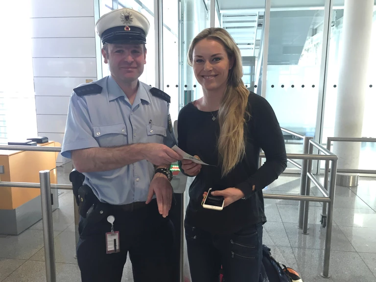 Ein Bundespolizist übergibt Lindsey Vonn am Münchner Flughafen einen Notreiseausweis — © Ein Bundespolizist übergibt Lindsey Vonn am Münchner Flughafen einen Notreiseausweis. Bild: Bundespolizei
