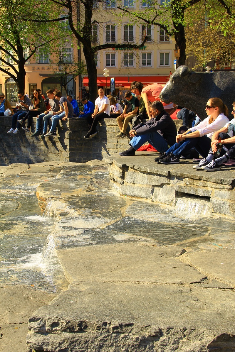 Menschen erholen sich am Rindermarktbrunnen
