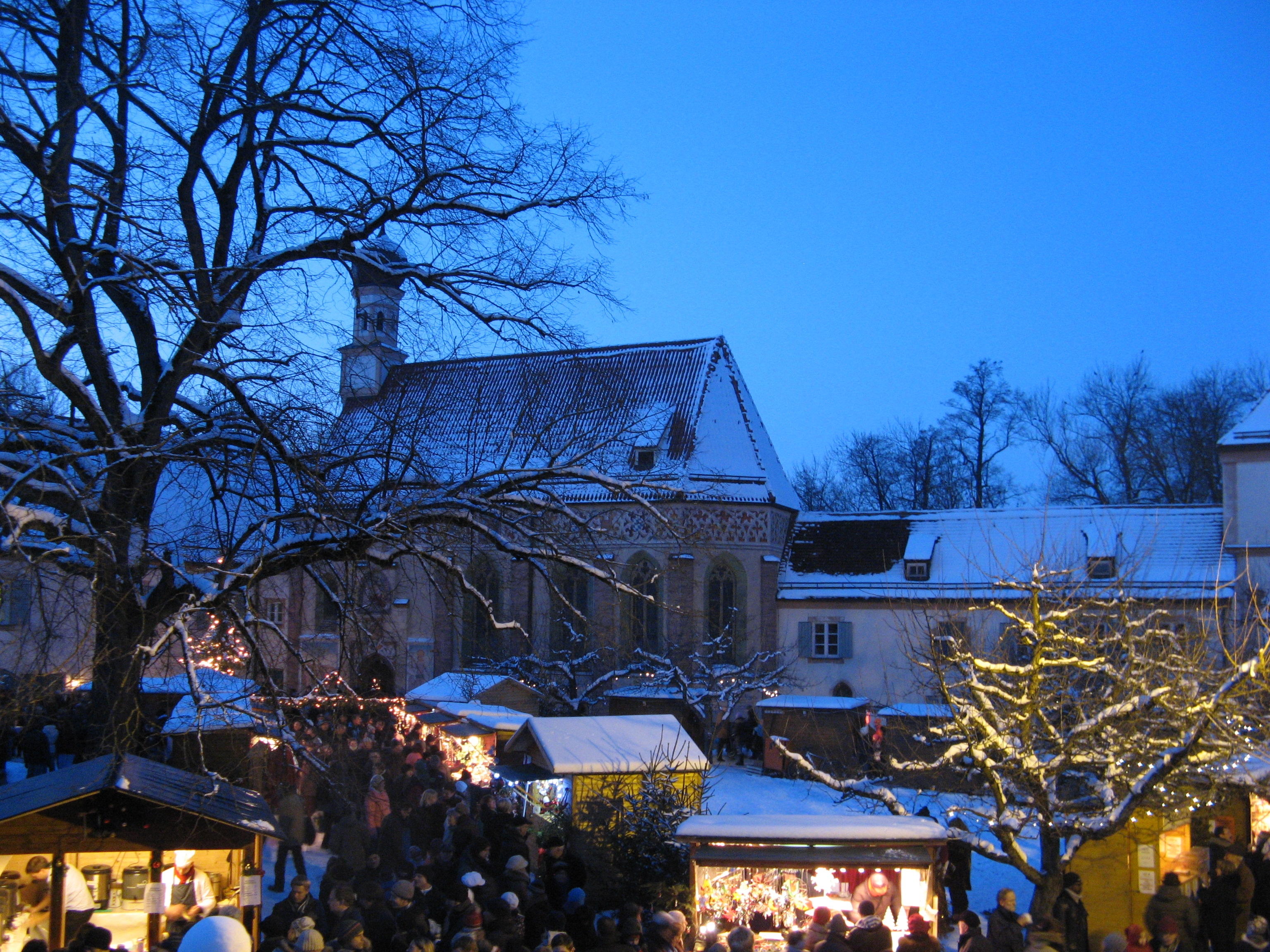 Hof mit beleuchteten Buden im Schloss Blutenburg, Foto Weihnachtsmarkt Schloss Blutenburg