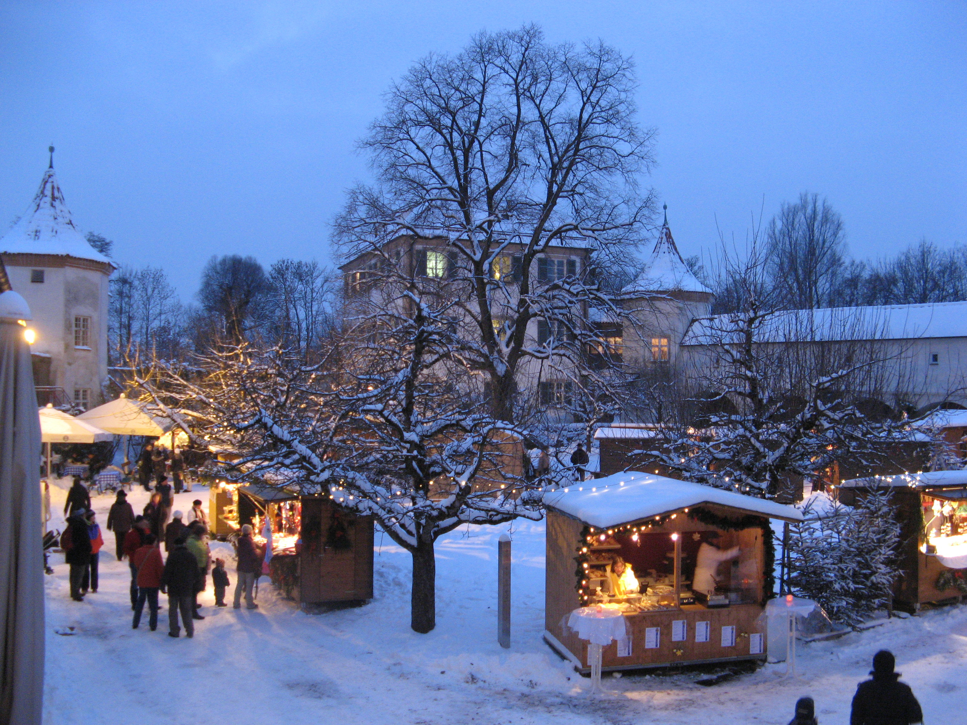 Schlosshof mit beleuchteten Buden im Schloss Blutenburg, Foto Weihnachtsmarkt Schloss Blutenburg