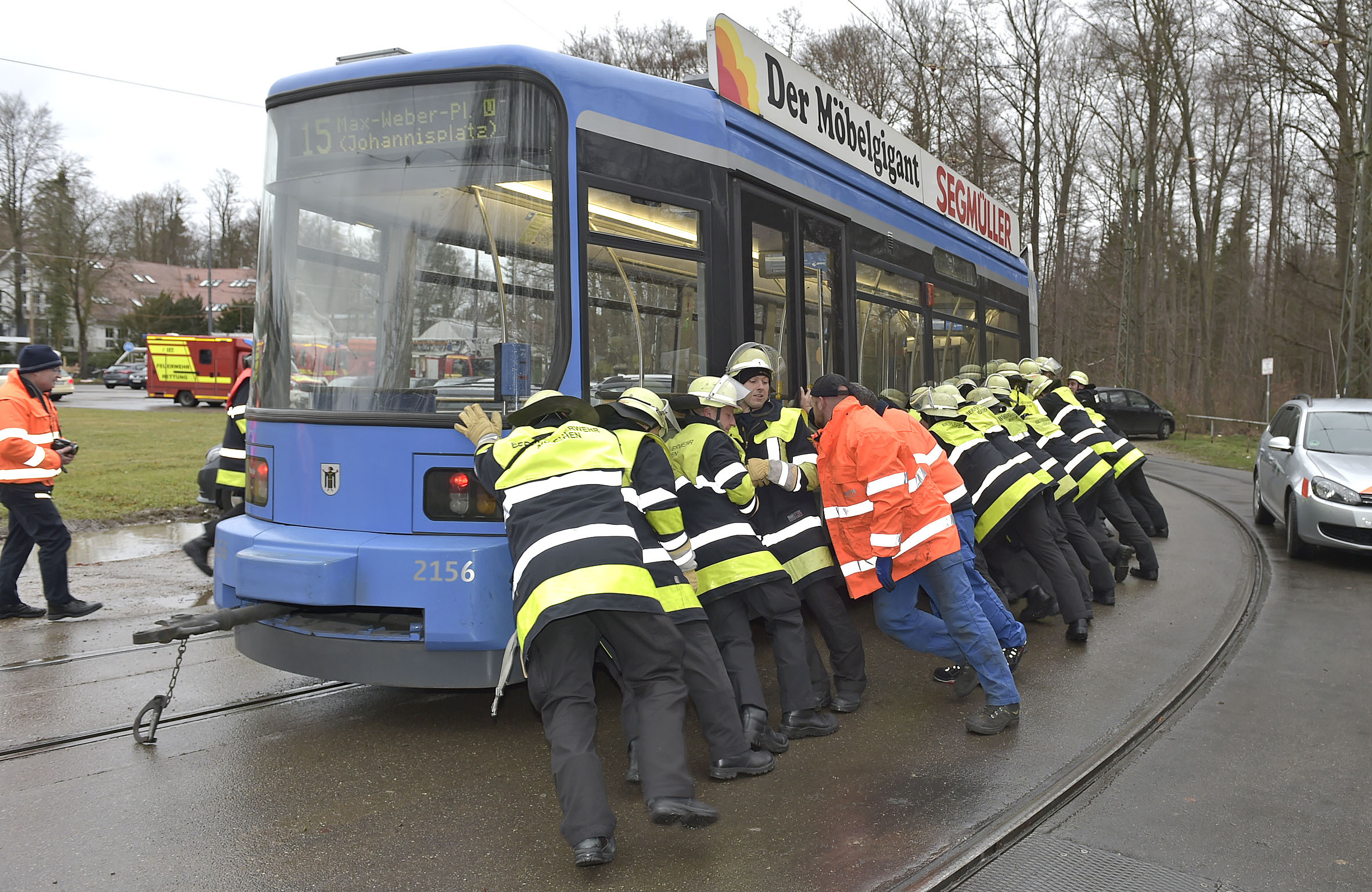 Feuerwehr schiebt entgleiste Tram zurück ins Gleisbett, Voller Körpereinsatz der Feuerwehr. Rechte: Foto der Berufsfeuerwehr München