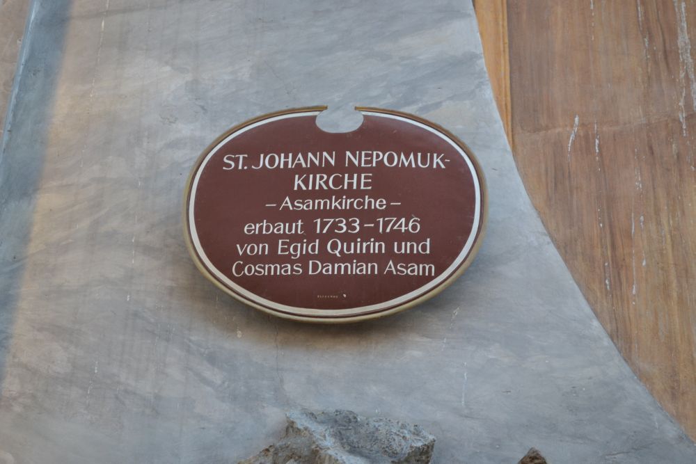 Schild mit Daten über die Bauherren Asambrüder und den Bau der Asam oder st Johann Nepomuk Kirche