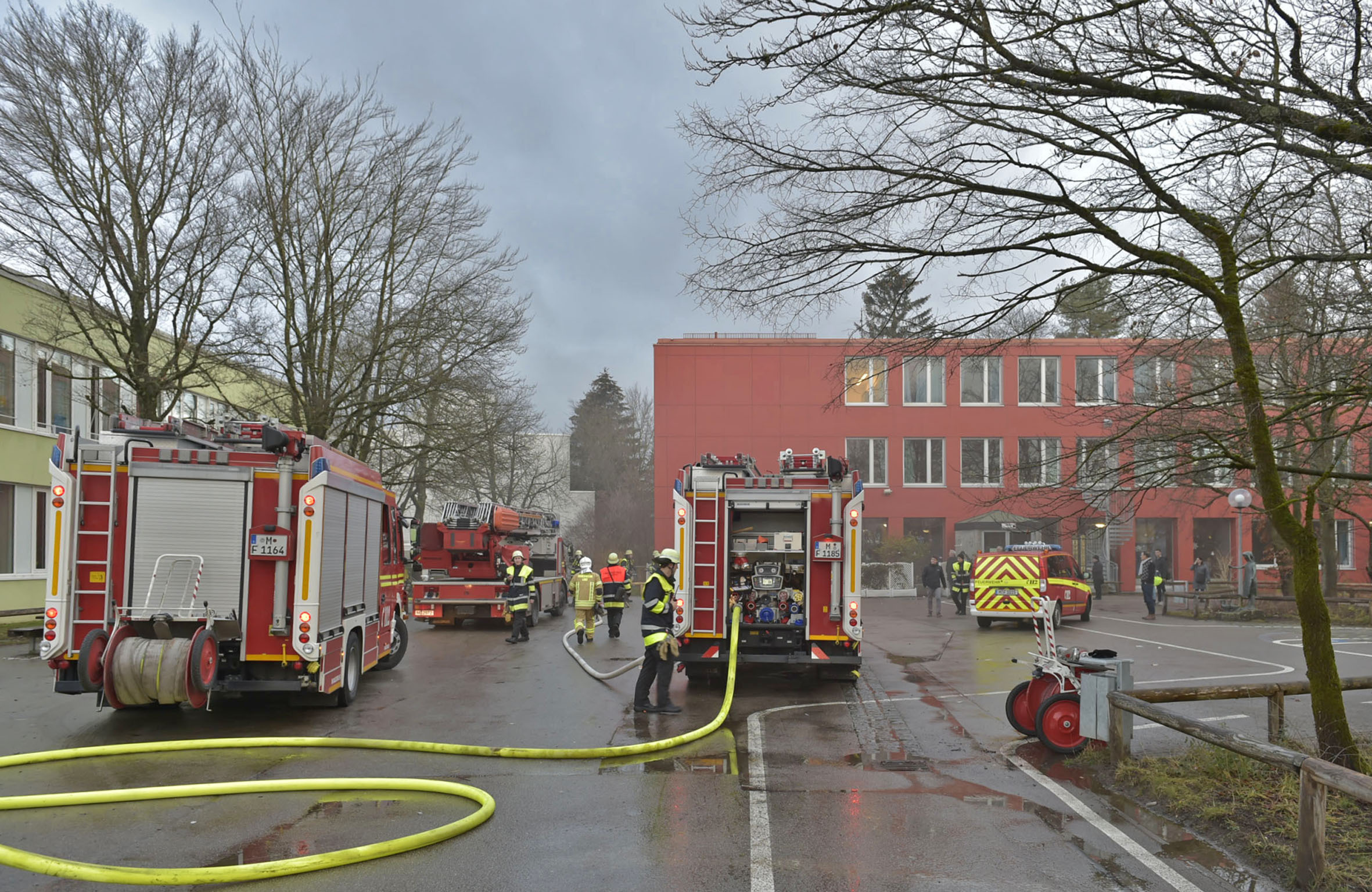Feuerwehr bei Brand in Schule, Die Einsatzkräfte vor der brennenden Schule - Foto: Berufsfeuerwehr München