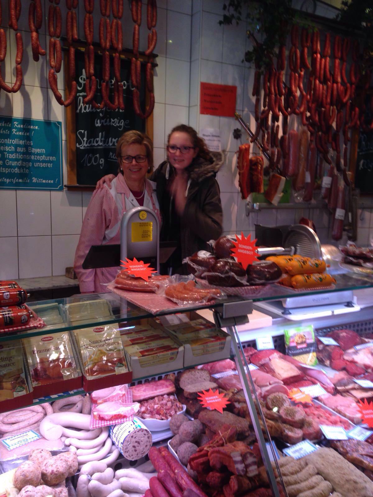 Metzgerieinhaberin gabi pichler mit enkeltochter hinter wurst und fleischtheke, Metzgereiinhaberin Gabi Pichler mit Enkeltochter
