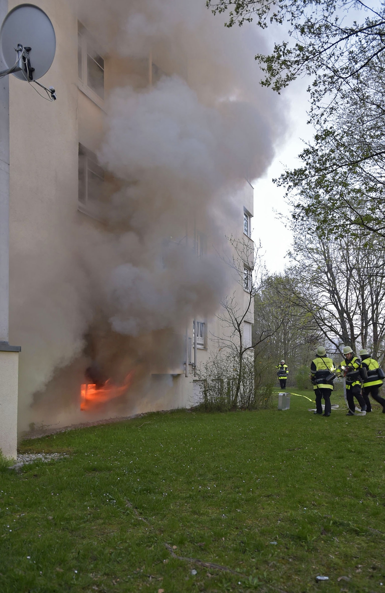  Helfer der Feuerwehr löschen einen Kellerbrand, Brand in einem vierstöckigem Haus in Neufriedenheim