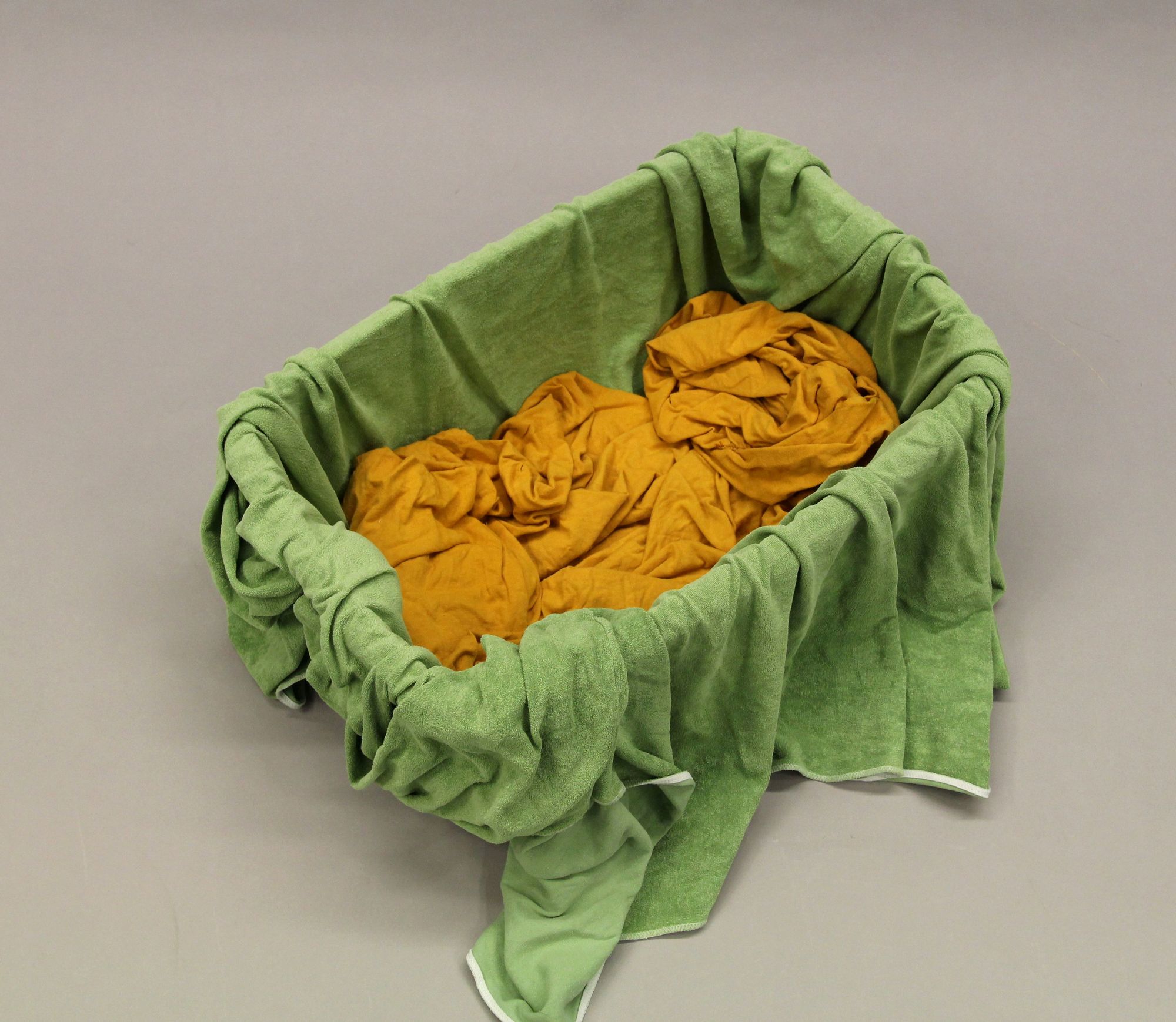 Wäschekorb mit grünem Betttuch und gelbem Bettlaken, Foto: Polizei