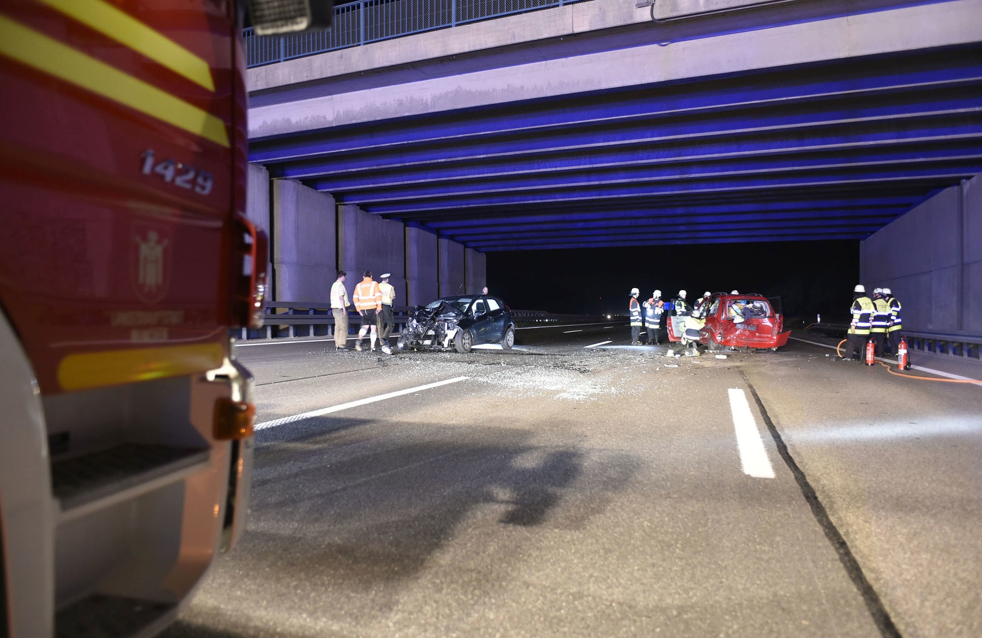 Unfallstelle unter Tunnel mit Feuerwehrwagen und Einsatzkräften, Feuerwehr München